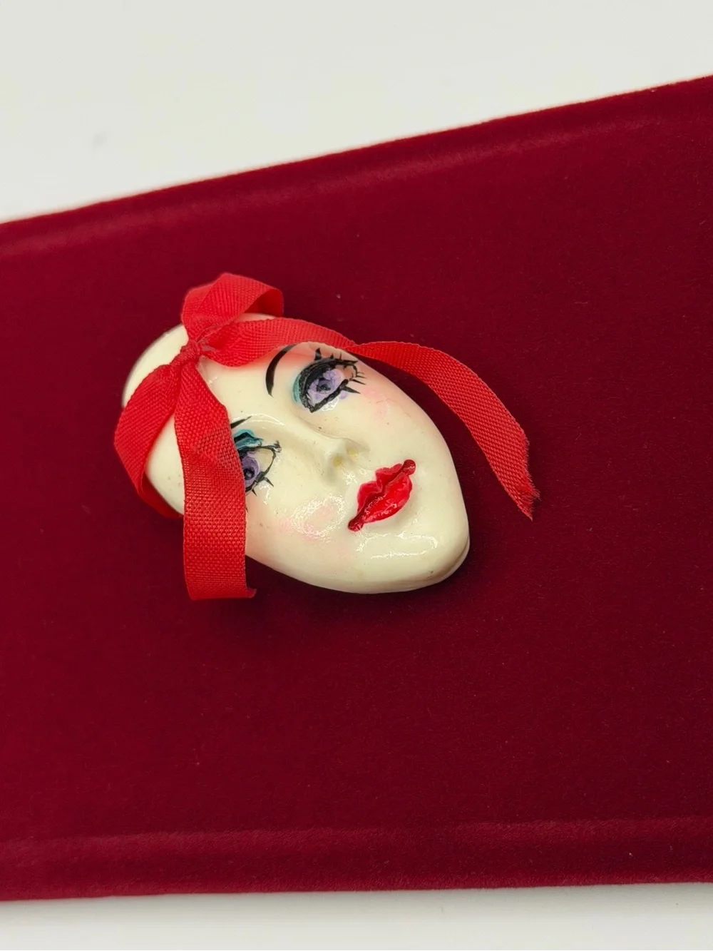 Vintage Face Brooch with Red Ribbon Accent